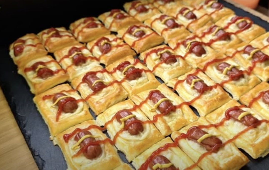 Pregătiți tartine crocante din foietaj cu mini cârnați și brânză topită. Acest aperitiv rapid și simplu va încânta pe cei din familie
